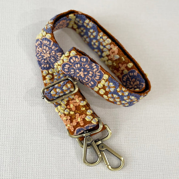 Photo of monochromatic hand-embroidered floral wool belt by Jenny Krauss, made in Peru with lead-free metal buckle. Versatile design with five sets of 2" spaced holes for hip or waist wear, featuring slight stretch for comfort.