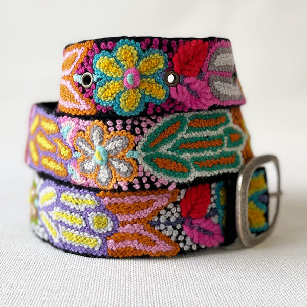 Photo of colorful hand-embroidered floral wool belt by Jenny Krauss, made in Peru with lead-free metal buckle. Versatile design with five sets of 2" spaced holes for hip or waist wear, featuring slight stretch for comfort.