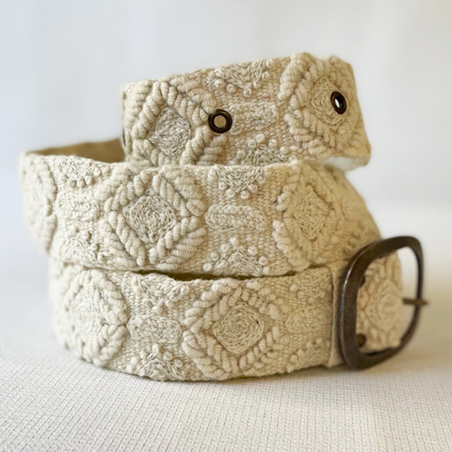 Photo of monochromatic  hand-embroidered floral wool belt by Jenny Krauss, made in Peru with lead-free metal buckle. Versatile design with five sets of 2" spaced holes for hip or waist wear, featuring slight stretch for comfort.