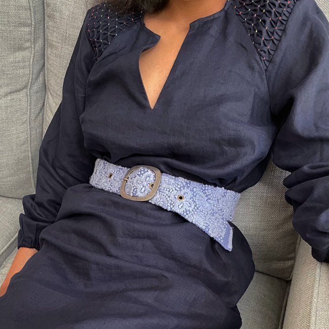 Photo of monochromatic hand-embroidered floral wool belt by Jenny Krauss, made in Peru with lead-free metal buckle. Versatile design with five sets of 2" spaced holes for hip or waist wear, featuring slight stretch for comfort.