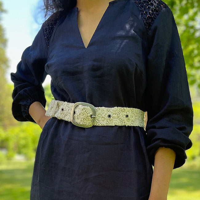 Photo of monochromatic hand-embroidered floral wool belt by Jenny Krauss, made in Peru with lead-free metal buckle. Versatile design with five sets of 2" spaced holes for hip or waist wear, featuring slight stretch for comfort.