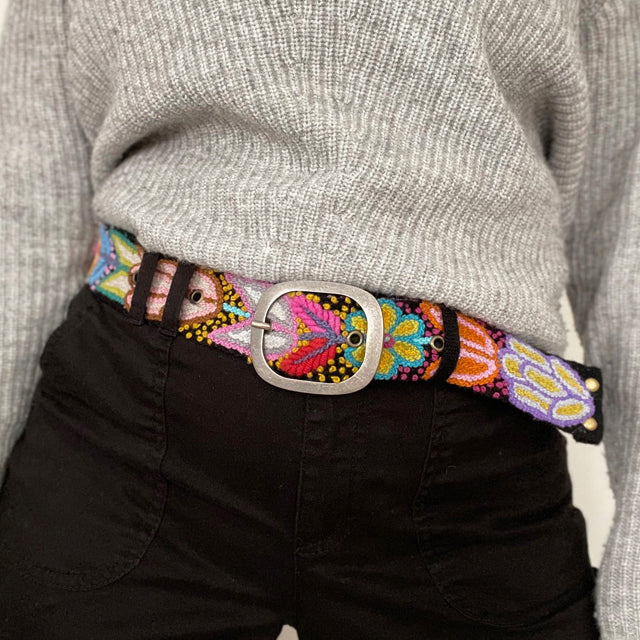 Photo of colorful hand-embroidered floral wool belt by Jenny Krauss, made in Peru with lead-free metal buckle. Versatile design with five sets of 2" spaced holes for hip or waist wear, featuring slight stretch for comfort.