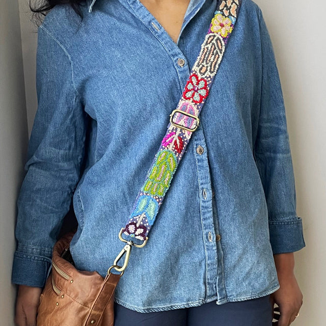 Photo of Jenny Krauss hand-embroidered wool strap from Peru. Multi-functional design serves as a bag or camera strap. Vibrant floral pattern, lead-free metal hardware, and adjustable length for versatile use. Elevate your style with this artisanal accessory.