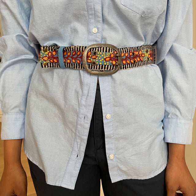 Photo of colorful hand-embroidered floral wool belt by Jenny Krauss, made in Peru with lead-free metal buckle. Versatile design with five sets of 2" spaced holes for hip or waist wear, featuring slight stretch for comfort.
