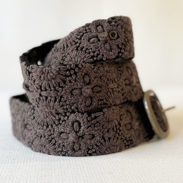 Photo of monochromatic hand-embroidered floral wool belt by Jenny Krauss, made in Peru with lead-free metal buckle. Versatile design with five sets of 2" spaced holes for hip or waist wear, featuring slight stretch for comfort.