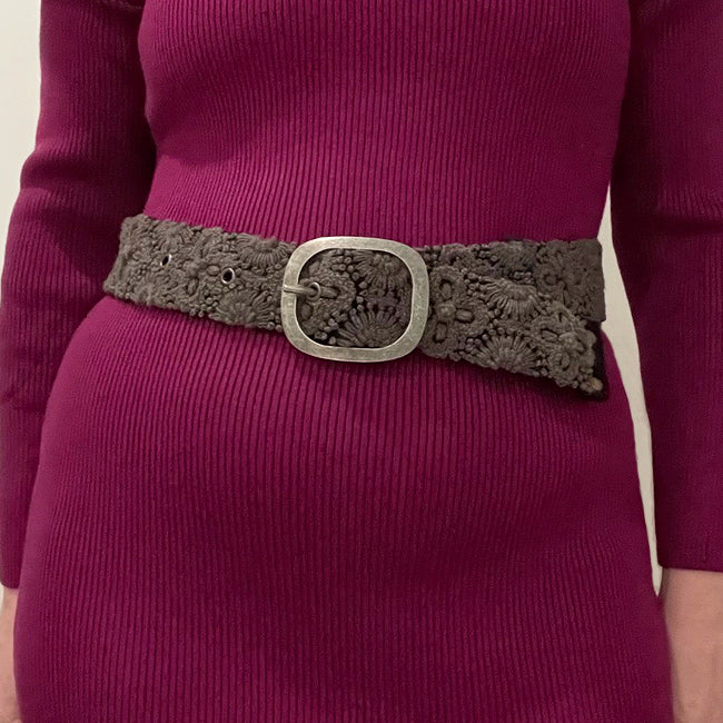 Photo of monochromatic hand-embroidered floral wool belt by Jenny Krauss, made in Peru with lead-free metal buckle. Versatile design with five sets of 2" spaced holes for hip or waist wear, featuring slight stretch for comfort.