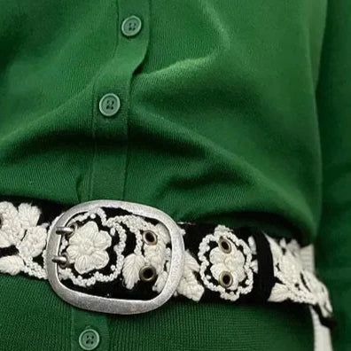 Photo of monochromatic hand-embroidered floral wool belt by Jenny Krauss, made in Peru with lead-free metal buckle. Versatile design with five sets of 2" spaced holes for hip or waist wear, featuring slight stretch for comfort.