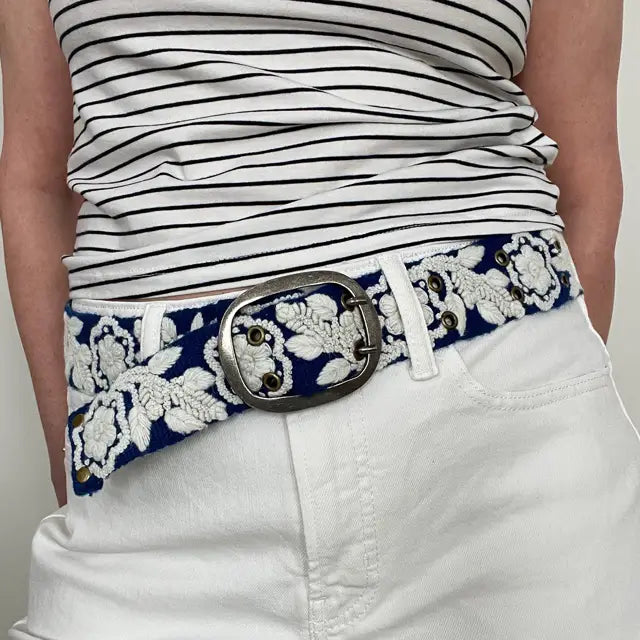 Photo of monochromatic  hand-embroidered floral wool belt by Jenny Krauss, made in Peru with lead-free metal buckle. Versatile design with five sets of 2" spaced holes for hip or waist wear, featuring slight stretch for comfort.