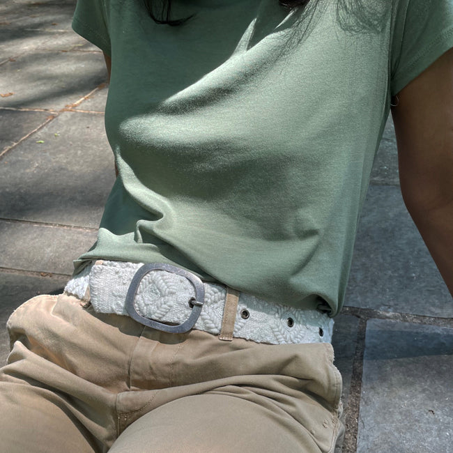 Photo of monochromatic  hand-embroidered floral wool belt by Jenny Krauss, made in Peru with lead-free metal buckle. Versatile design with five sets of 2" spaced holes for hip or waist wear, featuring slight stretch for comfort.