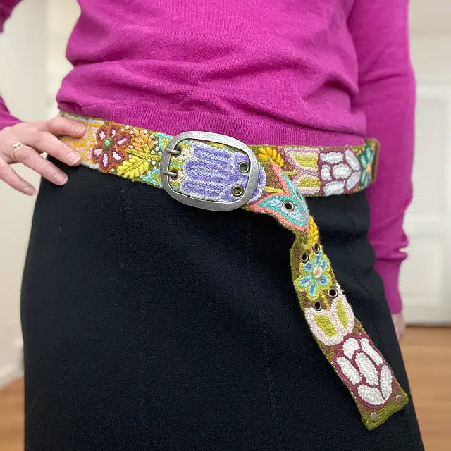 Photo of colorful hand-embroidered floral wool belt by Jenny Krauss, made in Peru with lead-free metal buckle. Versatile design with five sets of 2" spaced holes for hip or waist wear, featuring slight stretch for comfort.
