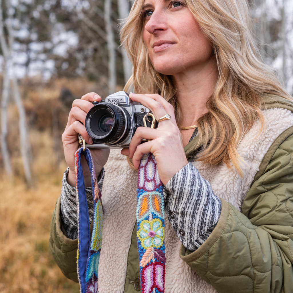 Photo of Jenny Krauss hand-embroidered wool strap from Peru. Multi-functional design serves as a bag or camera strap. Vibrant floral pattern, lead-free metal hardware, and adjustable length for versatile use. Elevate your style with this artisanal accessory.