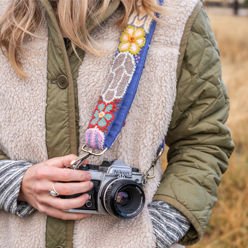 Photo of Jenny Krauss hand-embroidered wool strap from Peru. Multi-functional design serves as a bag or camera strap. Vibrant floral pattern, lead-free metal hardware, and adjustable length for versatile use. Elevate your style with this artisanal accessory.