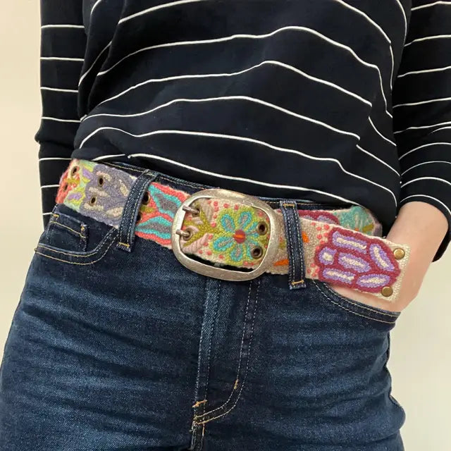 Photo of colorful hand-embroidered floral wool belt by Jenny Krauss, made in Peru with lead-free metal buckle. Versatile design with five sets of 2" spaced holes for hip or waist wear, featuring slight stretch for comfort.