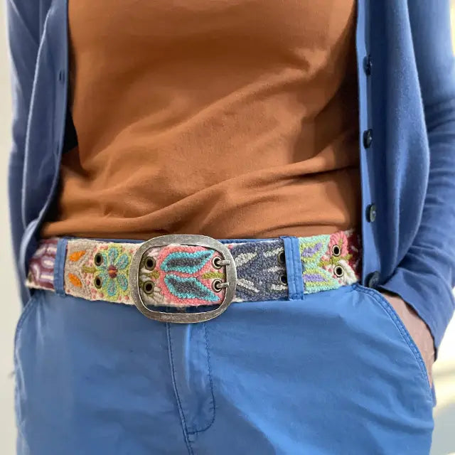 Photo of colorful hand-embroidered floral wool belt by Jenny Krauss, made in Peru with lead-free metal buckle. Versatile design with five sets of 2" spaced holes for hip or waist wear, featuring slight stretch for comfort.