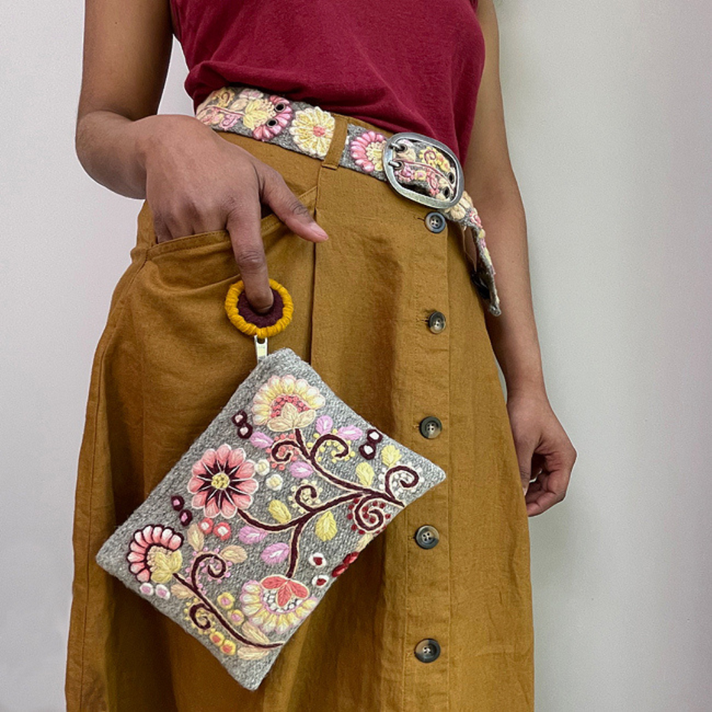 Photo of Jenny Krauss embroidered wool pouch, multi-functional travel accessory. Handcrafted with 100% wool, cotton lining, and sturdy metal zipper. Versatile for use as a wallet, clutch, or keepsake bag. Measures 5.5" L x 8" W. Designed in the U.S.A. and handmade in Peru by skilled artisans.
