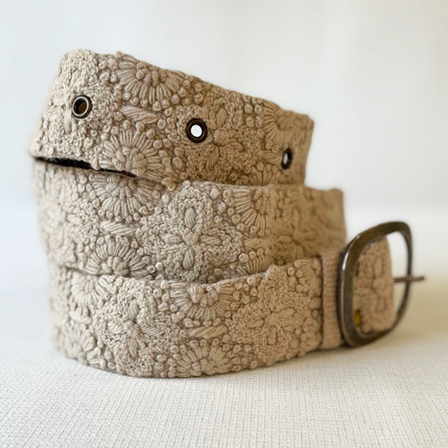 Photo of monochromatic  hand-embroidered floral wool belt by Jenny Krauss, made in Peru with lead-free metal buckle. Versatile design with five sets of 2" spaced holes for hip or waist wear, featuring slight stretch for comfort.