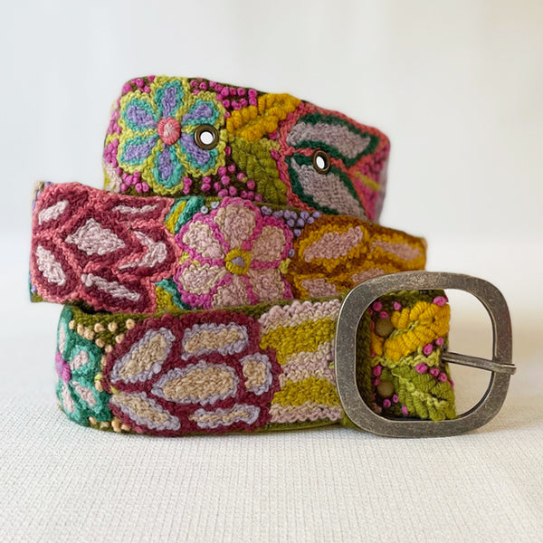 Photo of colorful hand-embroidered floral wool belt by Jenny Krauss, made in Peru with lead-free metal buckle. Versatile design with five sets of 2" spaced holes for hip or waist wear, featuring slight stretch for comfort.