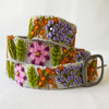 Photo of colorful hand-embroidered floral wool belt by Jenny Krauss, made in Peru with lead-free metal buckle. Versatile design with five sets of 2" spaced holes for hip or waist wear, featuring slight stretch for comfort.