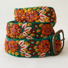 Photo of colorful hand-embroidered floral wool belt by Jenny Krauss, made in Peru with lead-free metal buckle. Versatile design with five sets of 2" spaced holes for hip or waist wear, featuring slight stretch for comfort.
