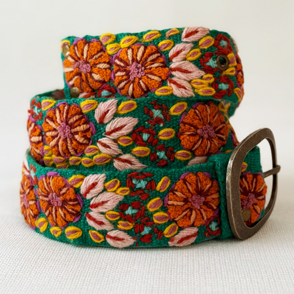 Photo of colorful hand-embroidered floral wool belt by Jenny Krauss, made in Peru with lead-free metal buckle. Versatile design with five sets of 2" spaced holes for hip or waist wear, featuring slight stretch for comfort.