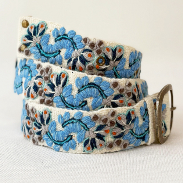 Photo of colorful hand-embroidered floral wool belt by Jenny Krauss, made in Peru with lead-free metal buckle. Versatile design with five sets of 2" spaced holes for hip or waist wear, featuring slight stretch for comfort.