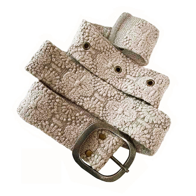 Photo of monochromatic  hand-embroidered floral wool belt by Jenny Krauss, made in Peru with lead-free metal buckle. Versatile design with five sets of 2" spaced holes for hip or waist wear, featuring slight stretch for comfort.