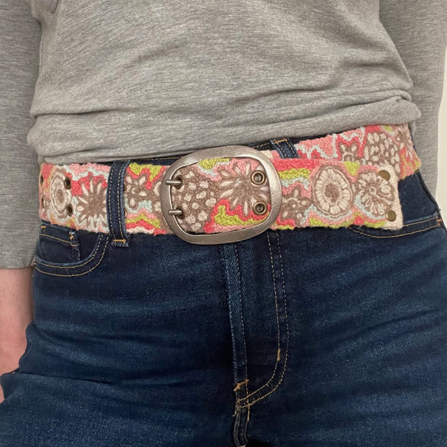 Photo of colorful hand-embroidered floral wool belt by Jenny Krauss, made in Peru with lead-free metal buckle. Versatile design with five sets of 2" spaced holes for hip or waist wear, featuring slight stretch for comfort.