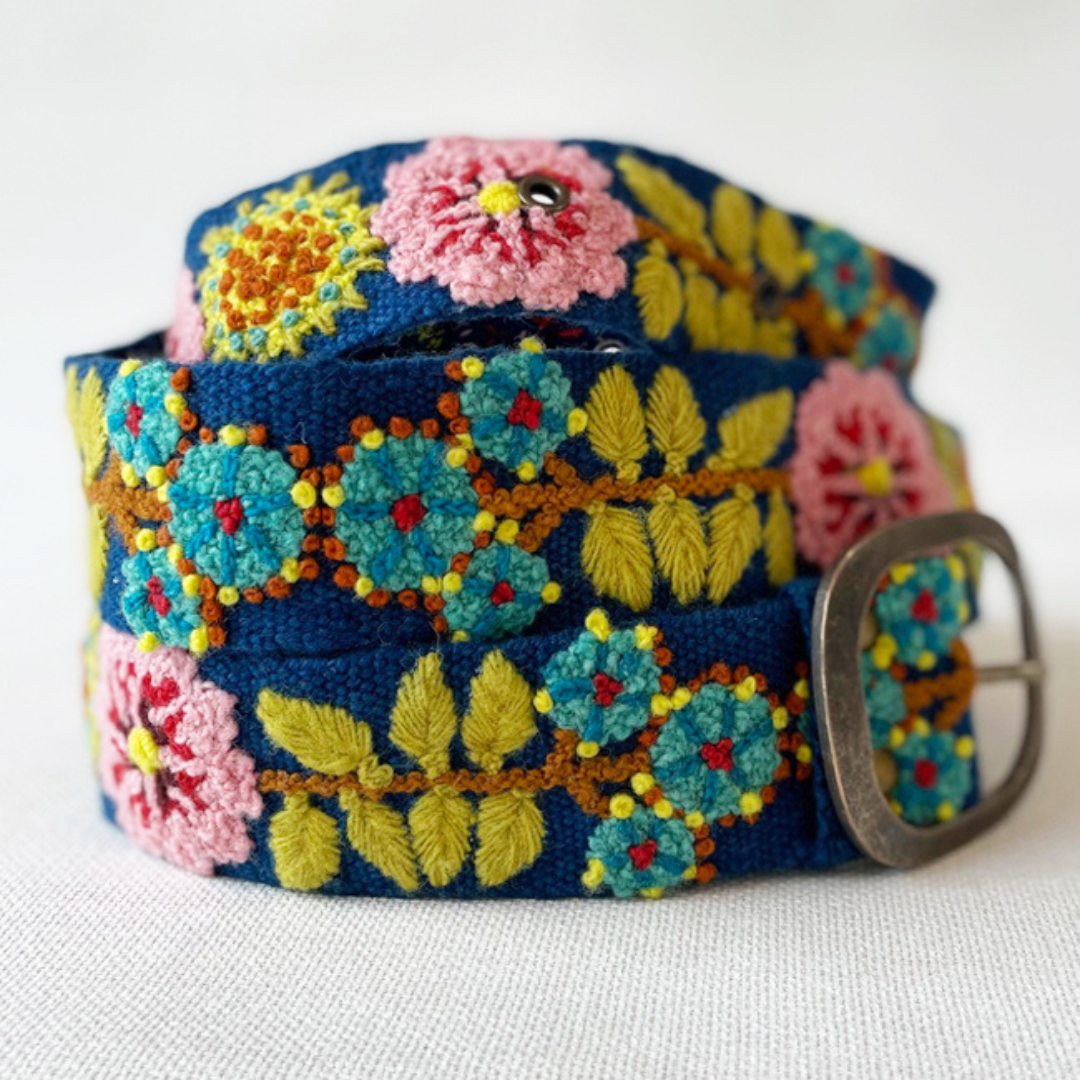 Photo of colorful hand-embroidered floral wool belt by Jenny Krauss, made in Peru with lead-free metal buckle. Versatile design with five sets of 2" spaced holes for hip or waist wear, featuring slight stretch for comfort.