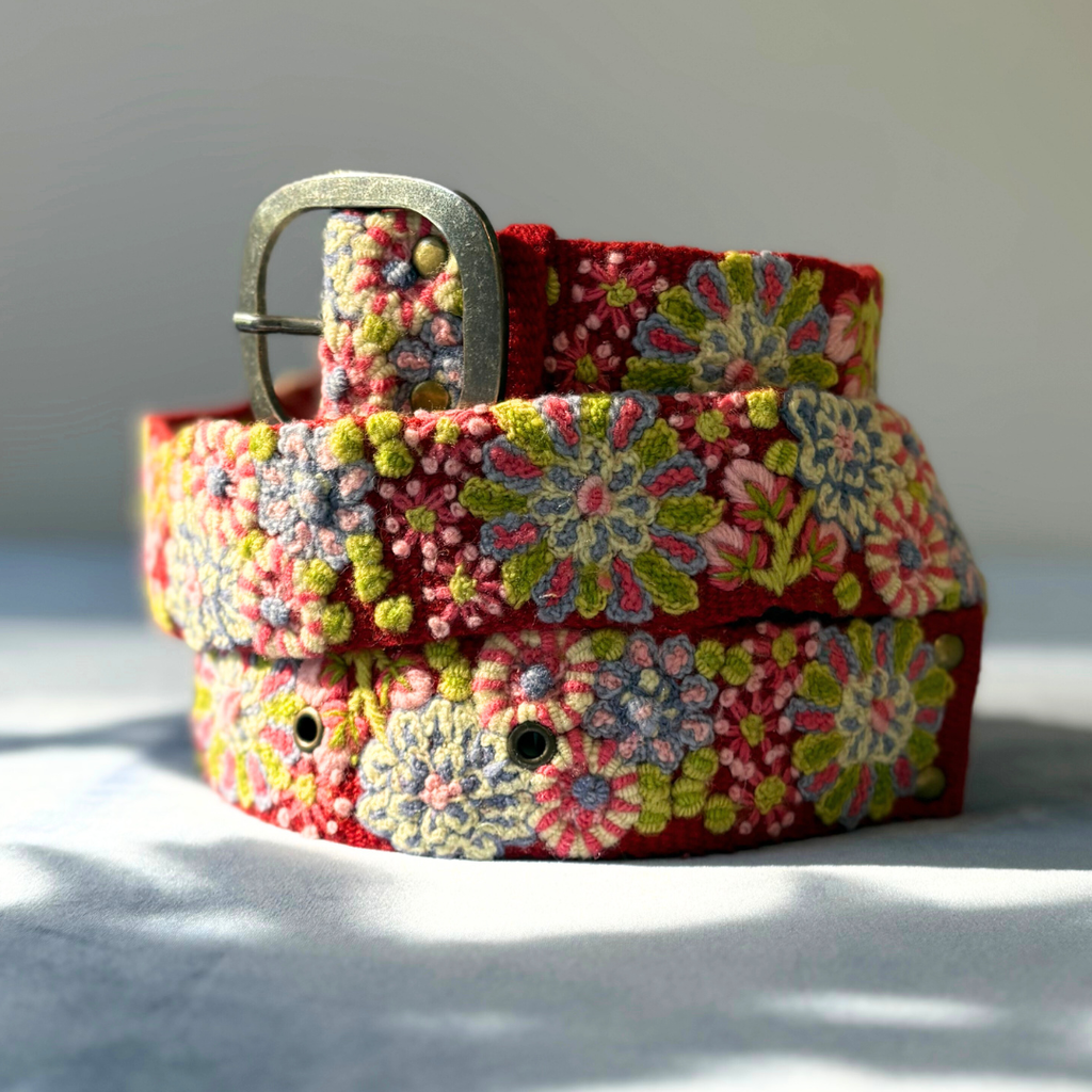 Floral patterned belt with a metal buckle on a light background