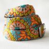 Photo of colorful hand-embroidered floral wool belt by Jenny Krauss, made in Peru with lead-free metal buckle. Versatile design with five sets of 2" spaced holes for hip or waist wear, featuring slight stretch for comfort.