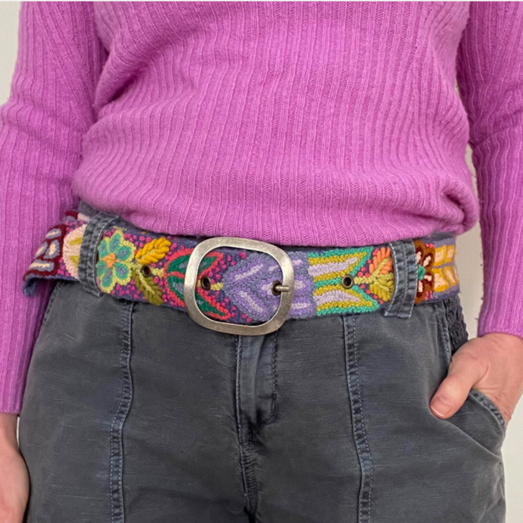 Photo of colorful hand-embroidered floral wool belt by Jenny Krauss, made in Peru with lead-free metal buckle. Versatile design with five sets of 2" spaced holes for hip or waist wear, featuring slight stretch for comfort.