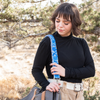 Photo of Jenny Krauss hand-embroidered wool strap from Peru. Multi-functional design serves as a bag or camera strap. Vibrant floral pattern, lead-free metal hardware, and adjustable length for versatile use. Elevate your style with this artisanal accessory.