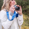 Photo of Jenny Krauss hand-embroidered wool strap from Peru. Multi-functional design serves as a bag or camera strap. Vibrant floral pattern, lead-free metal hardware, and adjustable length for versatile use. Elevate your style with this artisanal accessory.