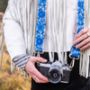 Photo of Jenny Krauss hand-embroidered wool strap from Peru. Multi-functional design serves as a bag or camera strap. Vibrant floral pattern, lead-free metal hardware, and adjustable length for versatile use. Elevate your style with this artisanal accessory.