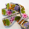 Photo of colorful hand-embroidered floral wool belt by Jenny Krauss, made in Peru with lead-free metal buckle. Versatile design with five sets of 2" spaced holes for hip or waist wear, featuring slight stretch for comfort.