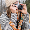 Photo of Jenny Krauss hand-embroidered wool strap from Peru. Multi-functional design serves as a bag or camera strap. Vibrant floral pattern, lead-free metal hardware, and adjustable length for versatile use. Elevate your style with this artisanal accessory.