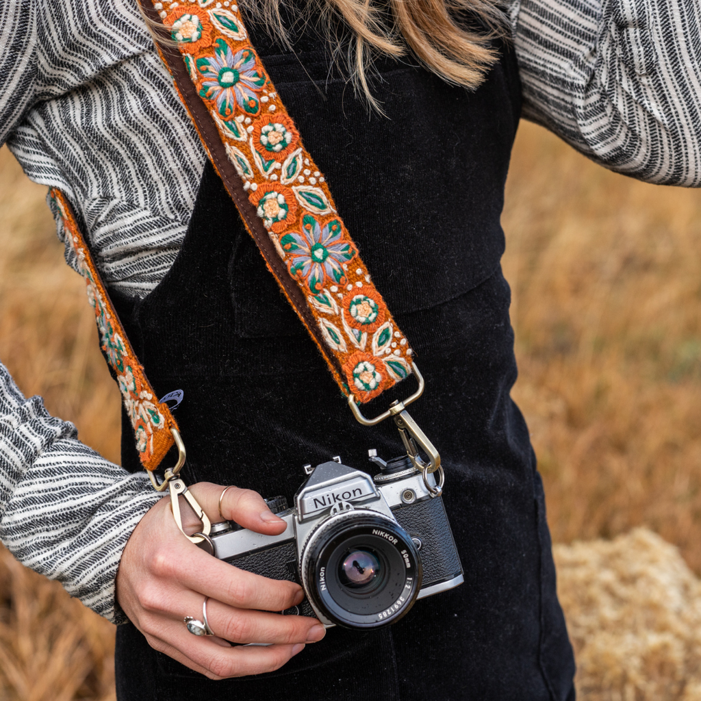 Photo of Jenny Krauss hand-embroidered wool strap from Peru. Multi-functional design serves as a bag or camera strap. Vibrant floral pattern, lead-free metal hardware, and adjustable length for versatile use. Elevate your style with this artisanal accessory.