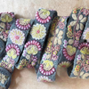 Photo of colorful hand-embroidered floral wool belt by Jenny Krauss, made in Peru with lead-free metal buckle. Versatile design with five sets of 2" spaced holes for hip or waist wear, featuring slight stretch for comfort.