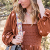 Photo of Jenny Krauss hand-embroidered wool strap from Peru. Multi-functional design serves as a bag or camera strap. Vibrant floral pattern, lead-free metal hardware, and adjustable length for versatile use. Elevate your style with this artisanal accessory.