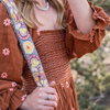 Photo of Jenny Krauss hand-embroidered wool strap from Peru. Multi-functional design serves as a bag or camera strap. Vibrant floral pattern, lead-free metal hardware, and adjustable length for versatile use. Elevate your style with this artisanal accessory.