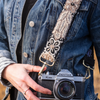 Photo of Jenny Krauss hand-embroidered wool strap from Peru. Multi-functional design serves as a camera or bag strap. Monochromatic floral pattern, lead-free metal hardware, and adjustable length for versatile use. Elevate your style with this artisanal accessory.