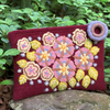 Photo of Jenny Krauss embroidered wool pouch, multi-functional travel accessory. Handcrafted with 100% wool, cotton lining, and sturdy metal zipper. Versatile for use as a wallet, clutch, or keepsake bag. Measures 5.5" L x 8" W. Designed in the U.S.A. and handmade in Peru by skilled artisans.