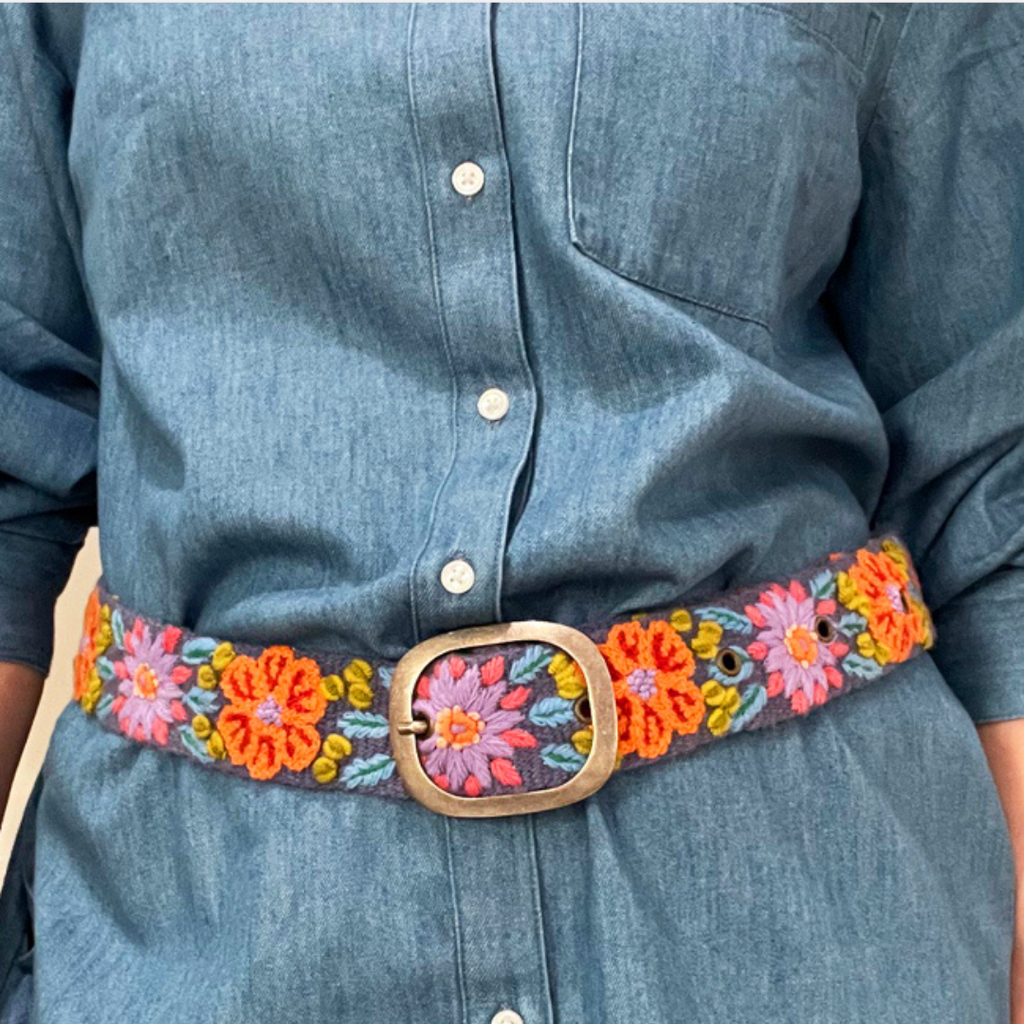 Photo of colorful hand-embroidered floral wool belt by Jenny Krauss, made in Peru with lead-free metal buckle. Versatile design with five sets of 2" spaced holes for hip or waist wear, featuring slight stretch for comfort.