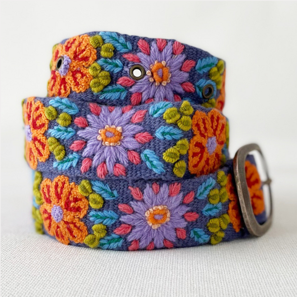 Photo of colorful hand-embroidered floral wool belt by Jenny Krauss, made in Peru with lead-free metal buckle. Versatile design with five sets of 2" spaced holes for hip or waist wear, featuring slight stretch for comfort.